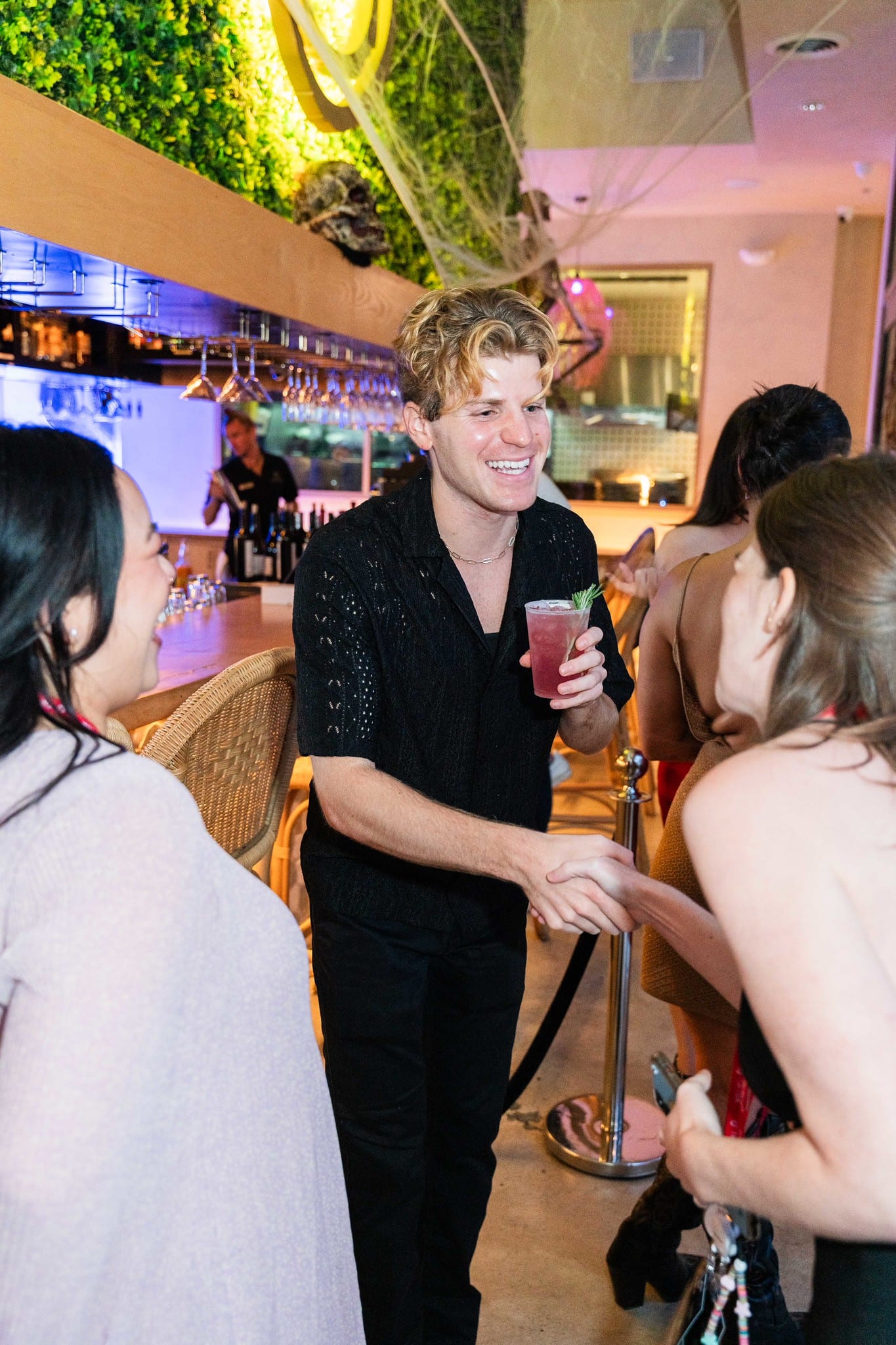 Guests mingling and pouring drinks during the rooftop reception at the TikTok and Ulta Beauty #TikTokBeauty dinner on the LouLou rooftop in Santa Monica