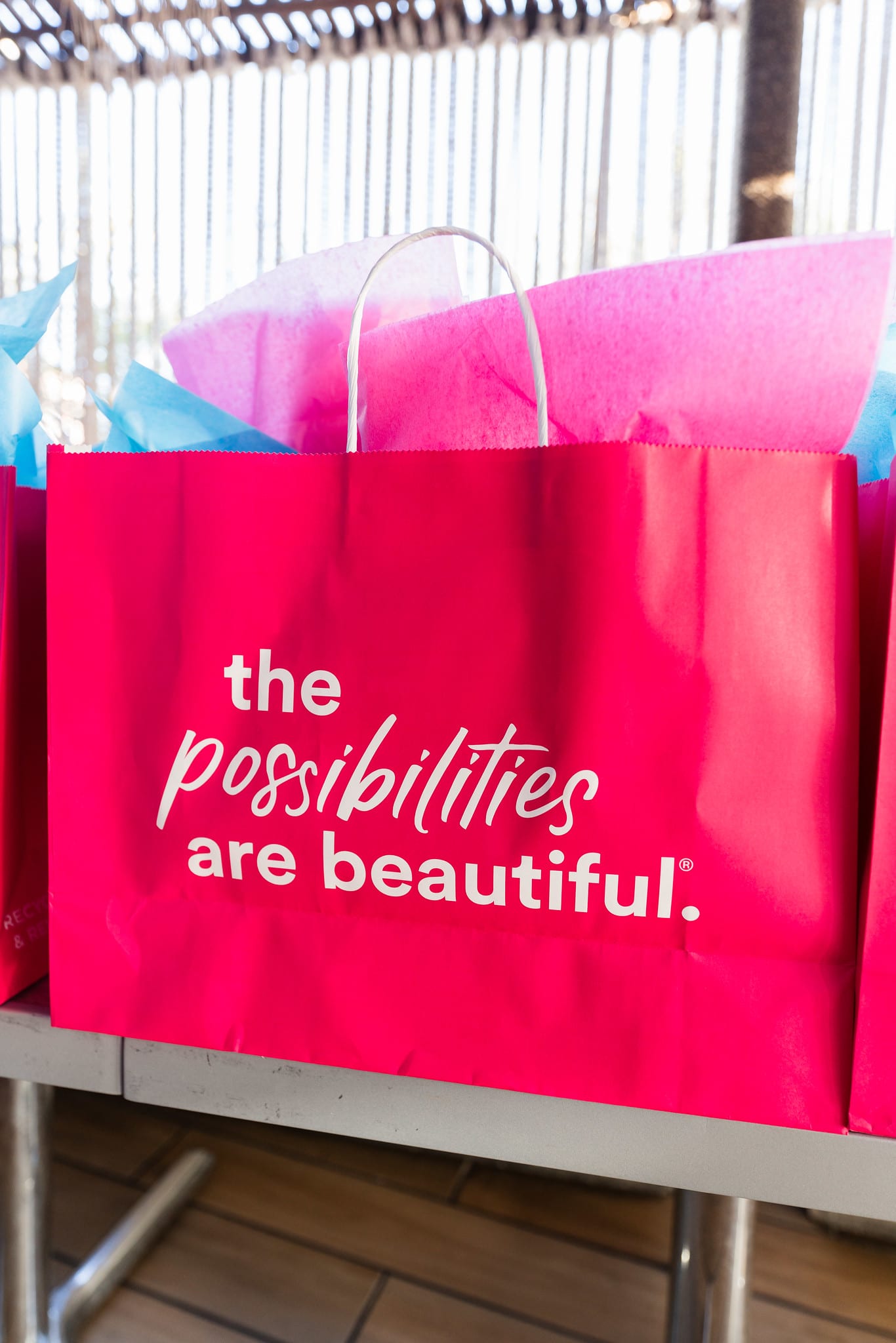 A pink Ulta Beauty bag printed with the possibilities are beautiful, standing on a rooftop chair at the TikTok and Ulta Beauty #TikTokBeauty dinner on the LouLou rooftop in Santa Monica