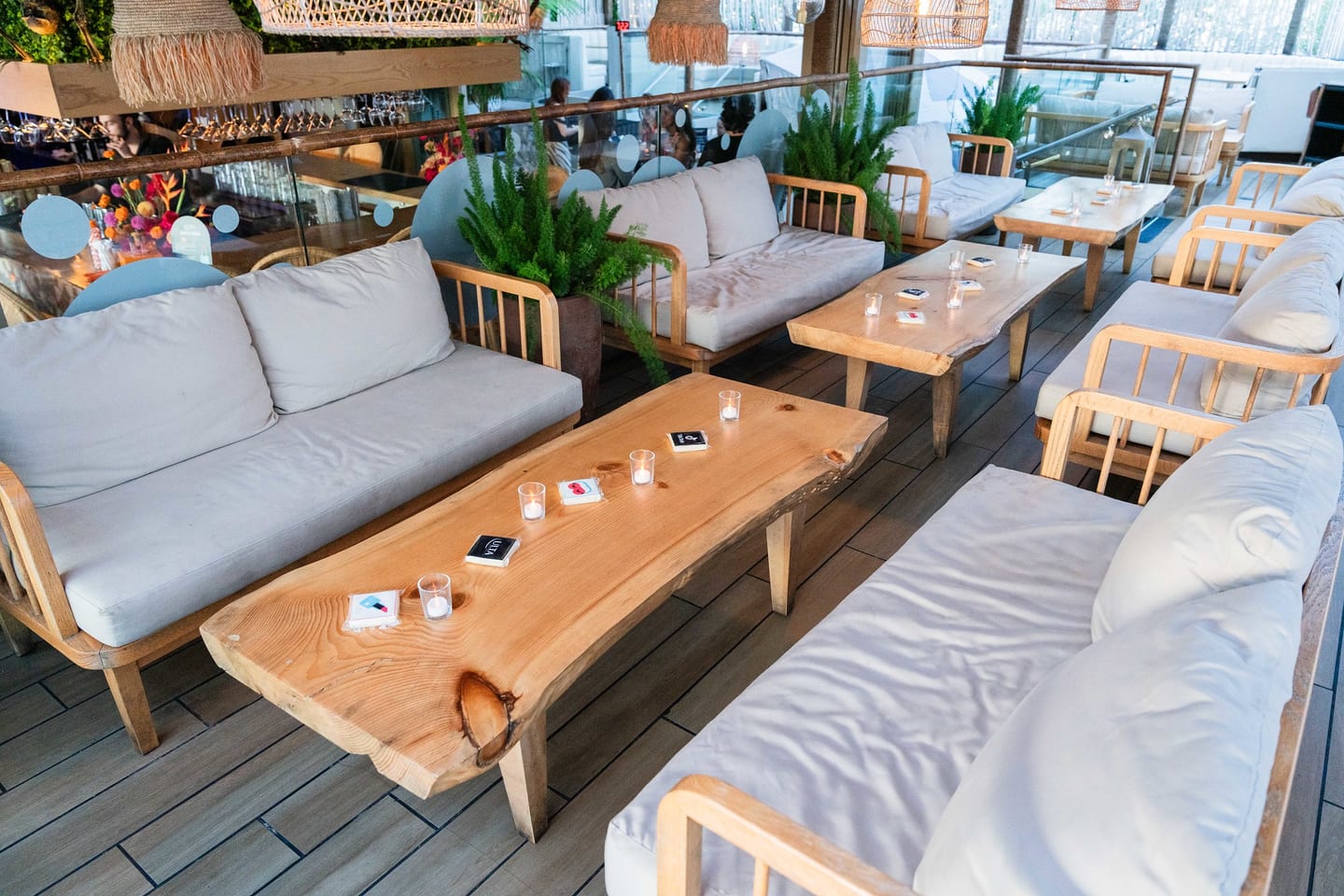 Empty rooftop daybeds and live-edge wood tables set for guests at the TikTok and Ulta Beauty #TikTokBeauty dinner on the LouLou rooftop in Santa Monica