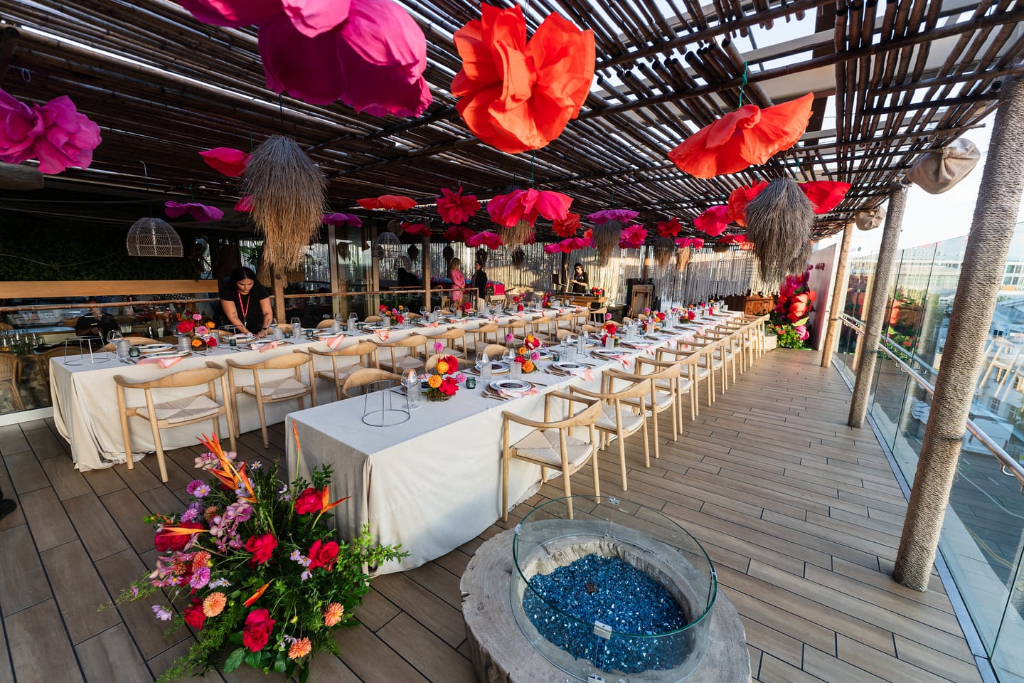 A wide rooftop view showing the set dining table, a glass fire pit and suspended paper flowers at the TikTok and Ulta Beauty #TikTokBeauty dinner on the LouLou rooftop in Santa Monica