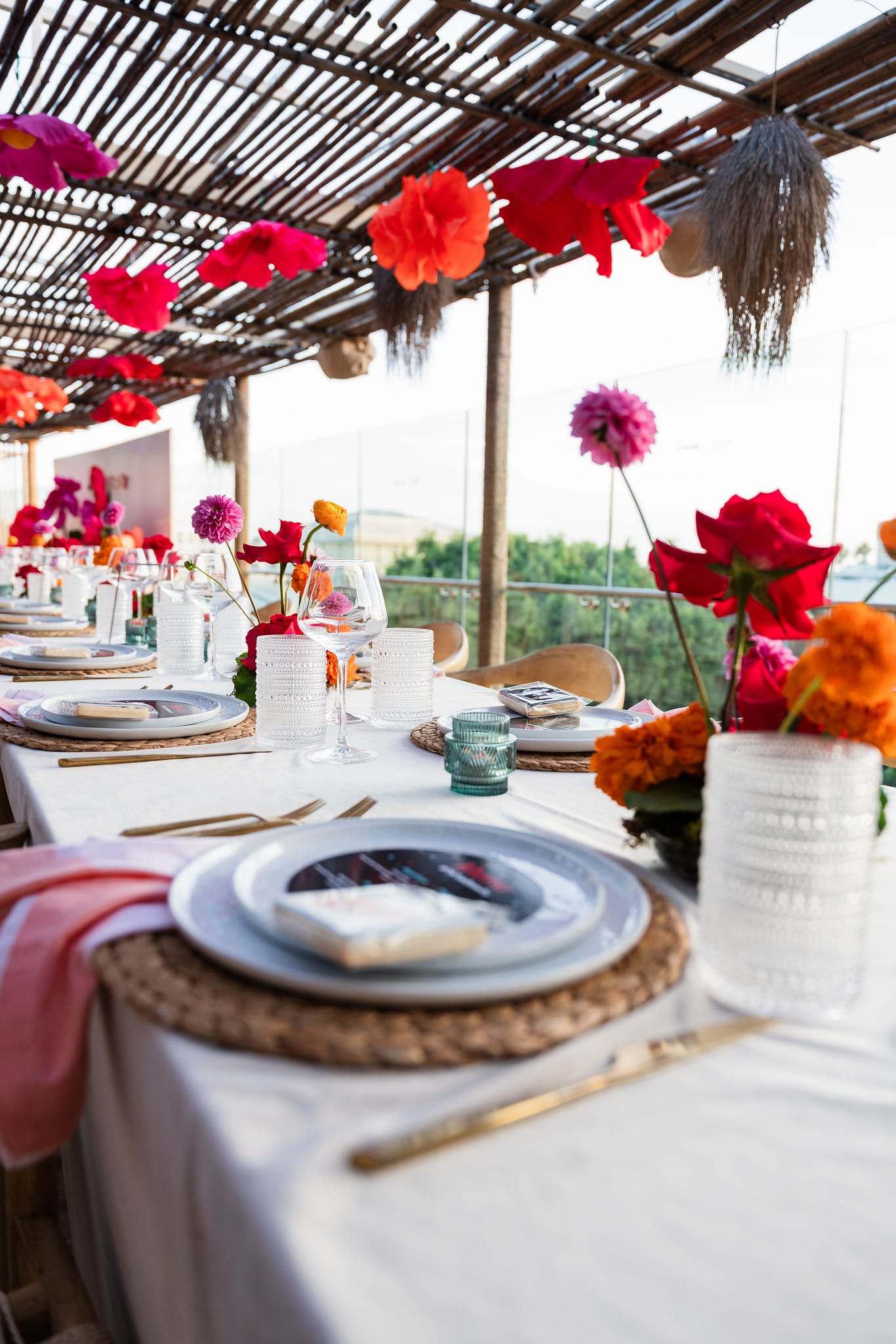 A single place setting photographed from above with florals and hanging paper flowers overhead at the TikTok and Ulta Beauty #TikTokBeauty dinner on the LouLou rooftop in Santa Monica