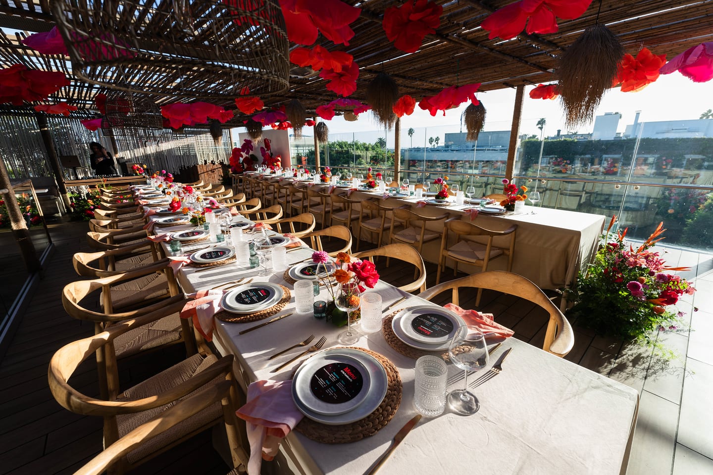 The set rooftop dining table photographed wide beneath hanging paper flowers before guests were seated at the TikTok and Ulta Beauty #TikTokBeauty dinner on the LouLou rooftop in Santa Monica