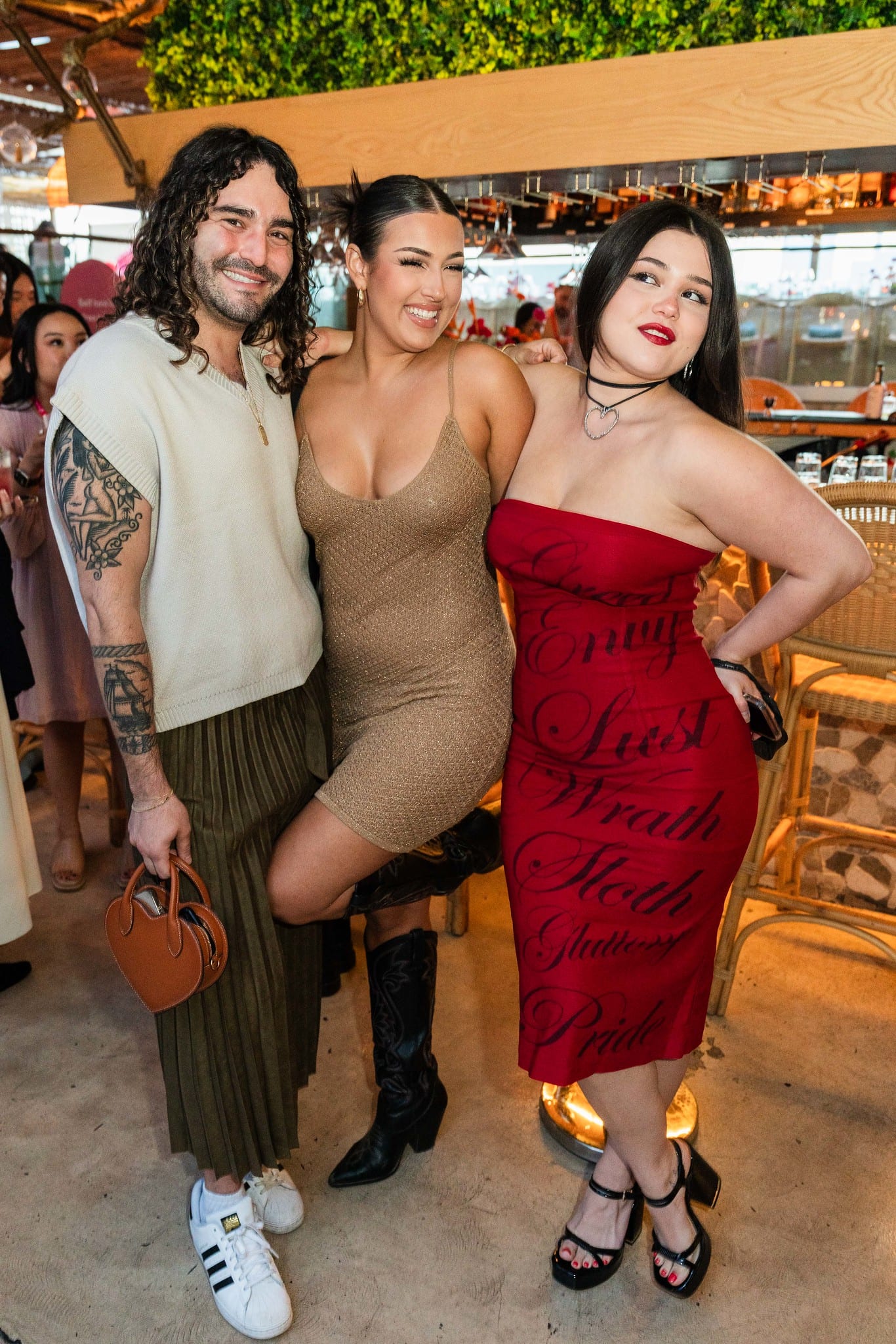 Three guests posing together in front of the rooftop railing at the TikTok and Ulta Beauty #TikTokBeauty dinner on the LouLou rooftop in Santa Monica