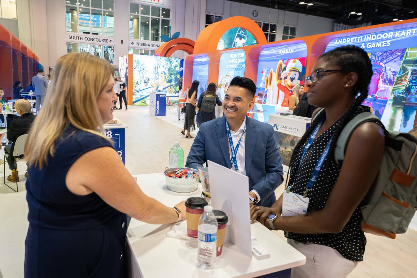 Attendees networking over coffee at a Florida tourism pavilion on the IPW travel trade show floor