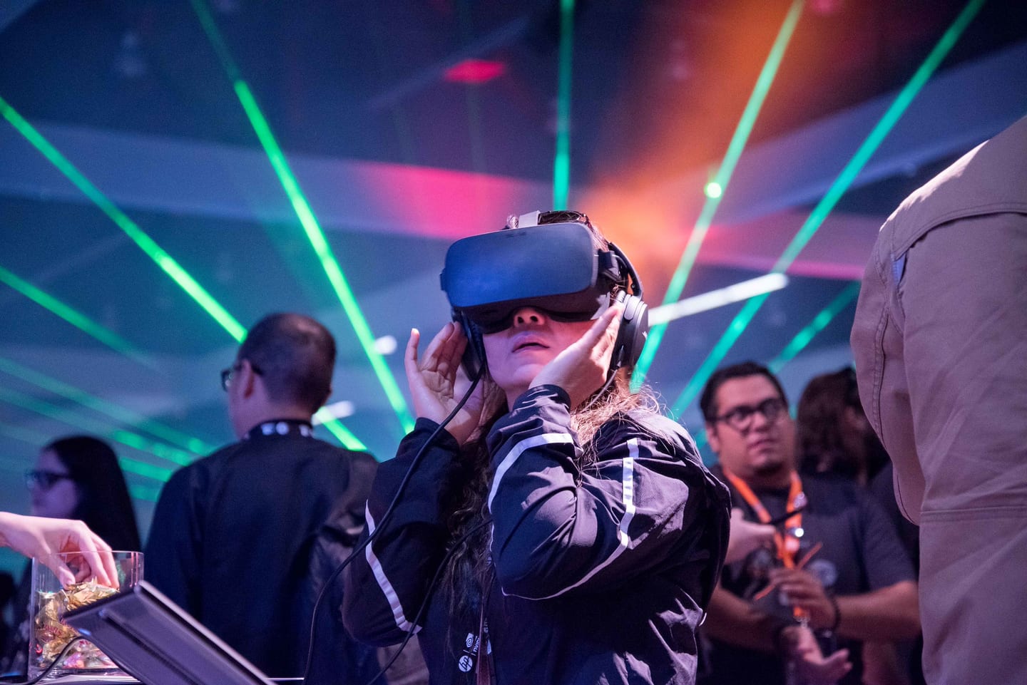 A guest wearing a VR headset under green and orange laser light at a virtual reality brand activation in Los Angeles